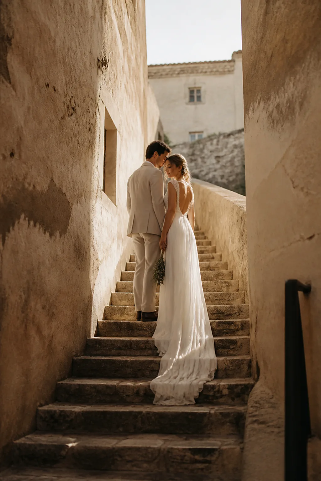 A couple pausing on a narrow ancient stone stairway in a hilltop village